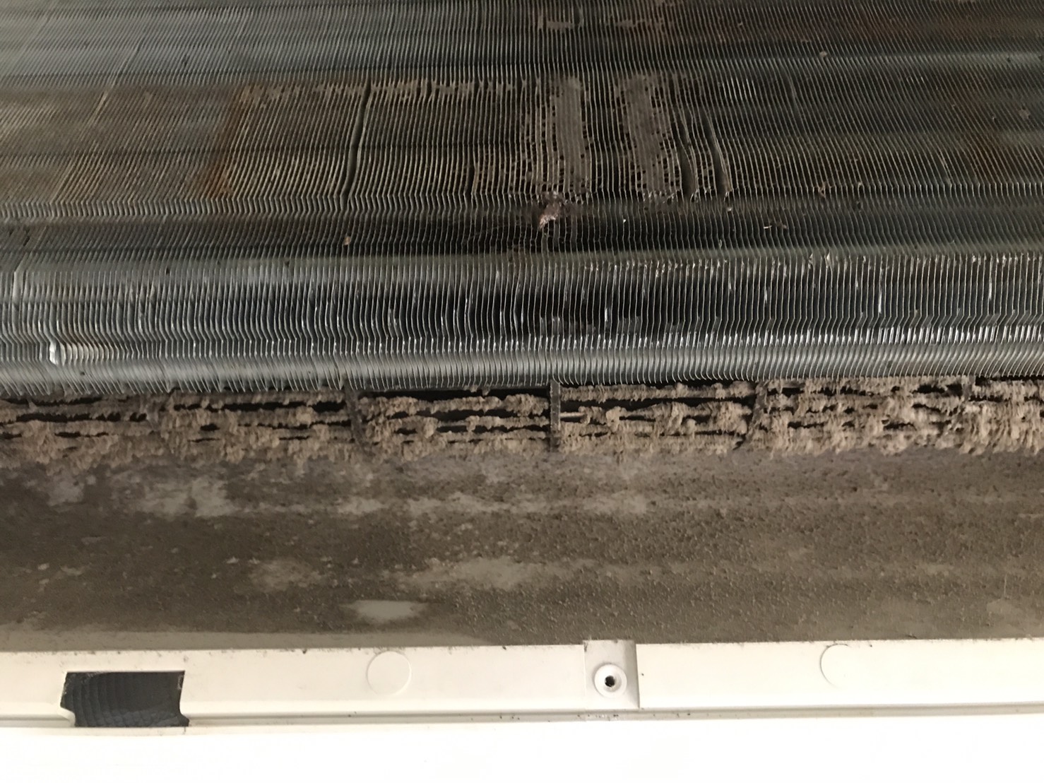 SK-105 重油污鋁潔劑清洗前：室內機鋁鰭片迎風面灰塵與纖維厚層堆積，縫隙被覆蓋